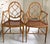 A stylish pair of bespoke English faux bamboo armchairs that feature oval backs with intricate interlaced latticework...
