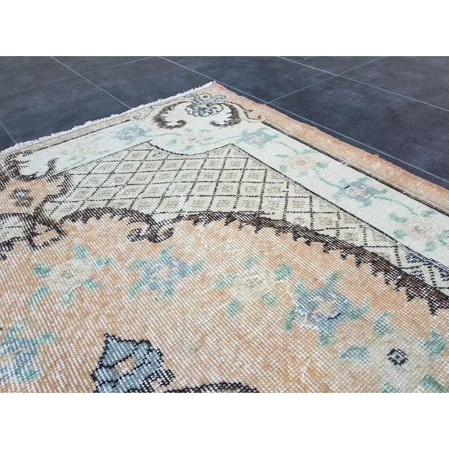 This is a vintage Turkish Oushak rug from the 1960s. The piece was hand-knotted.