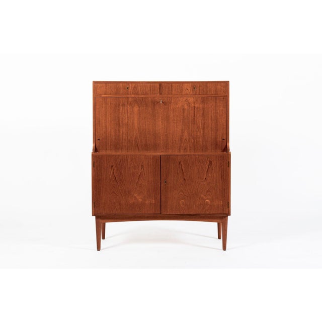This vintage mid-century Danish modern teak secretary desk attributed to H.P. Hansen was made in Denmark in the 1960s. It...