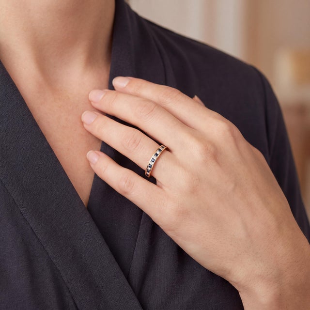 A late 20th-century 14k gold wedding ring featuring 17 brilliant-cut diamonds and 17 blue sapphires. The band is adorned...