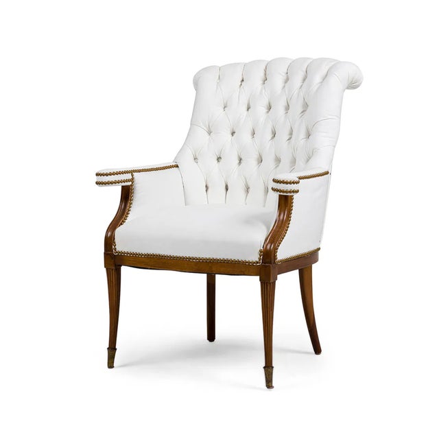 A handsome pair of Grosfeld House style wingback armchairs, newly upholstered in crisp ivory linen and finished with...