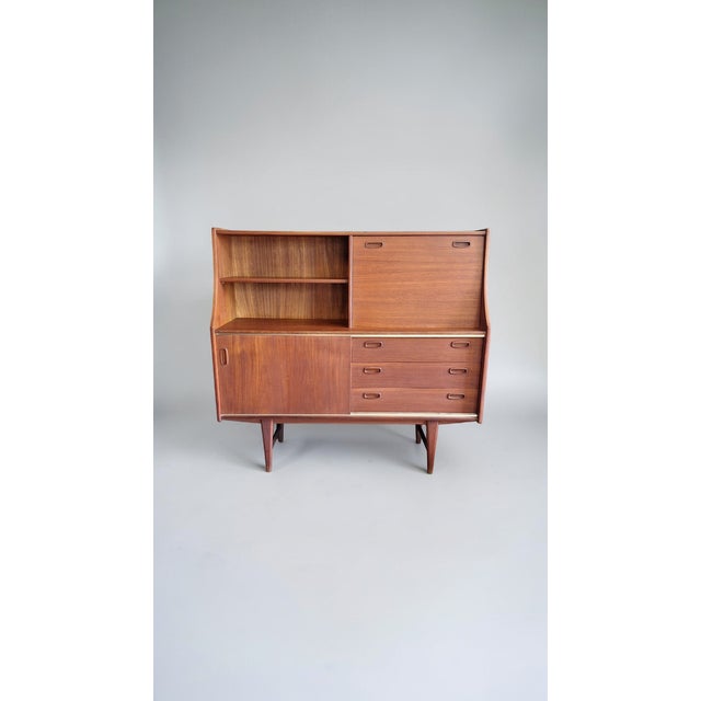 Tall teak sideboard made in the 1960s by the Belgian company OMF (Omer Lefevre Meubelfabriek). The upper section of the...