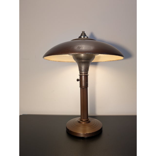 This table lamp is a futuristic flying saucer lamp or "UFO" lamp from circa 1950s. This one is finished in a metallic...