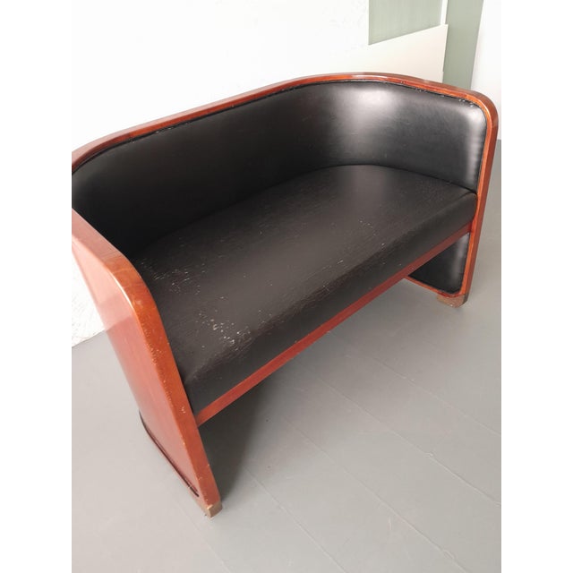 A two-seater Club Sofa / settee, designed in the Art Deco style. It features a distinctive curved 'tub' or 'barrel' back...