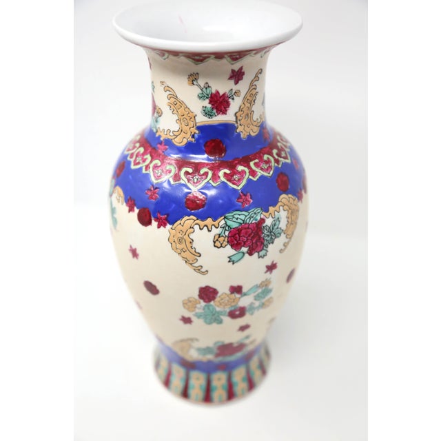 A vintage, hand-painted ceramic vase, with an off-white base, red roses, and blue, green and yellow accents. Good condition.