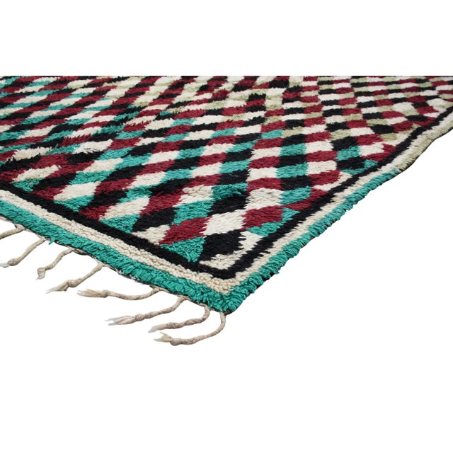 Hand-knotted Moroccan rug with low wool pile. Lively and complex Berber pattern throughout in maroon and teal gradation....