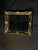 Ornate decorative wall mirror featuring a black frame with antique gold detailing and carved-style scrollwork. The piece...