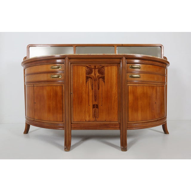 An exceptional walnut sideboard designed by Maurice Dufrène in France, circa 1911, bridging the lyrical elegance of Art...