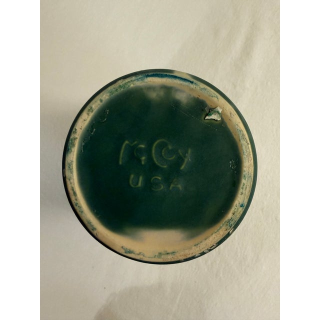 A beautiful vintage McCoy pottery pedestal planter featuring a rich deep green matte glaze and elegant vertical carved...