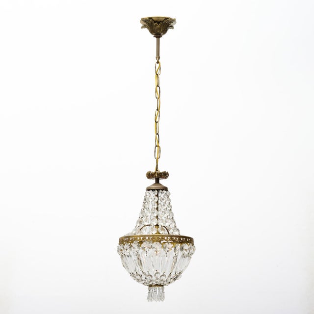 An elegant French crystal chandelier, circa 1920, designed in the refined Louis XVI tradition. The chandelier features a...