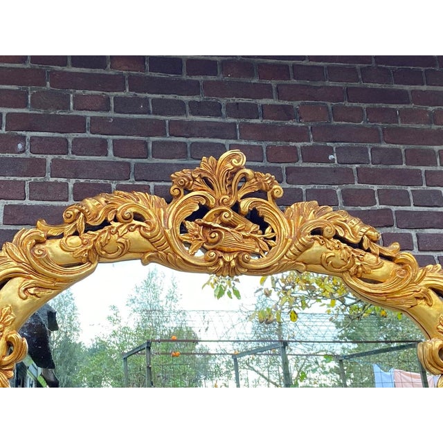 A striking 1970s Italian Baroque Rococo-style wall mirror, handcrafted from solid beechwood and finished in a warm antique...