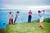 Hong Kong Golf by Toni Frissell A golfer tees off on a coastal course in Hong Kong, with two caddies and an opponent...