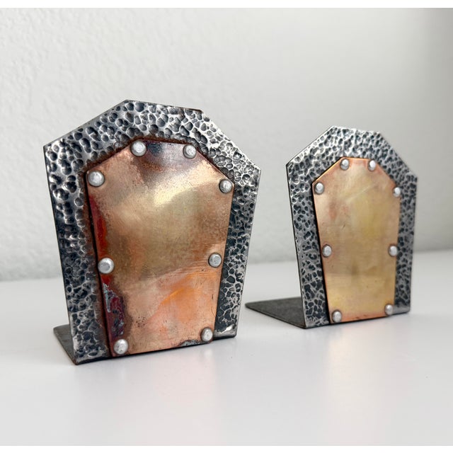 A pair of primitive style, mixed metal bookends with a hammered, aged silver metal body and a copper center with rivet...