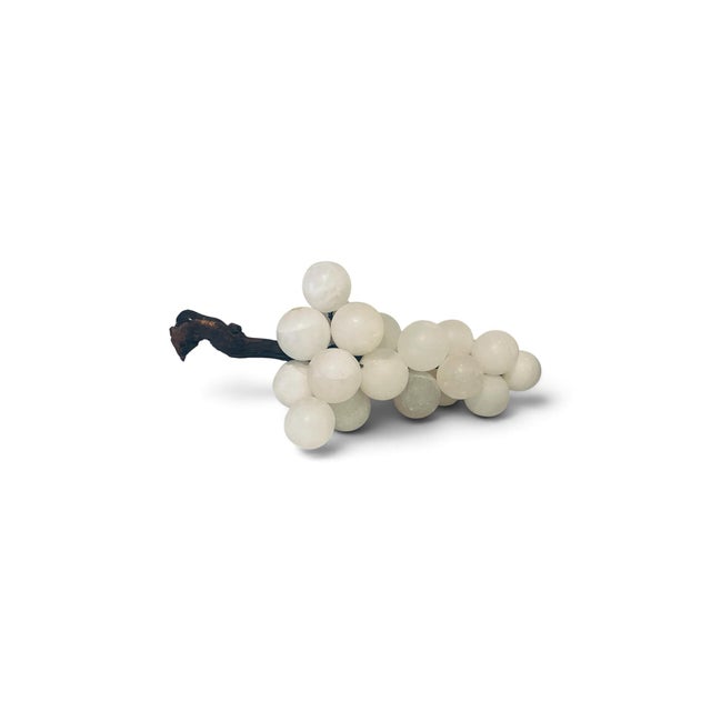 Each grape is individually sculpted from smooth alabaster, displaying subtle variations in tone and translucency that...