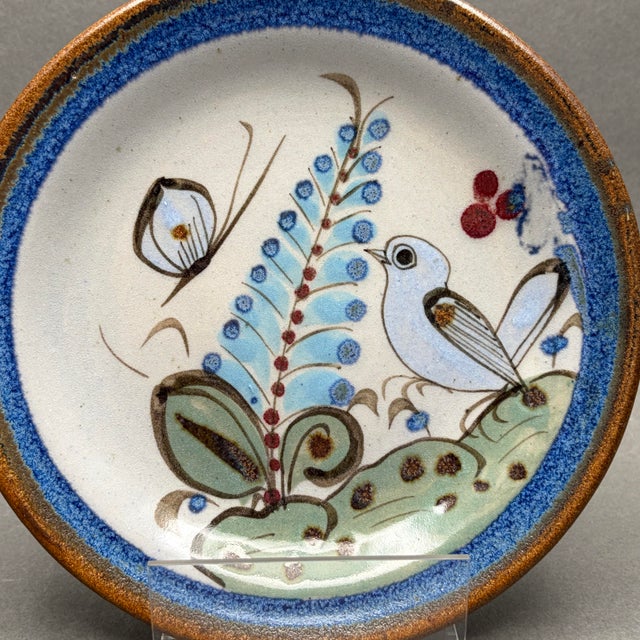 • Ken Edwards Tonala pottery plate with hand-painted bird, butterfly and botanical design. • Made in Mexico, likely circa...