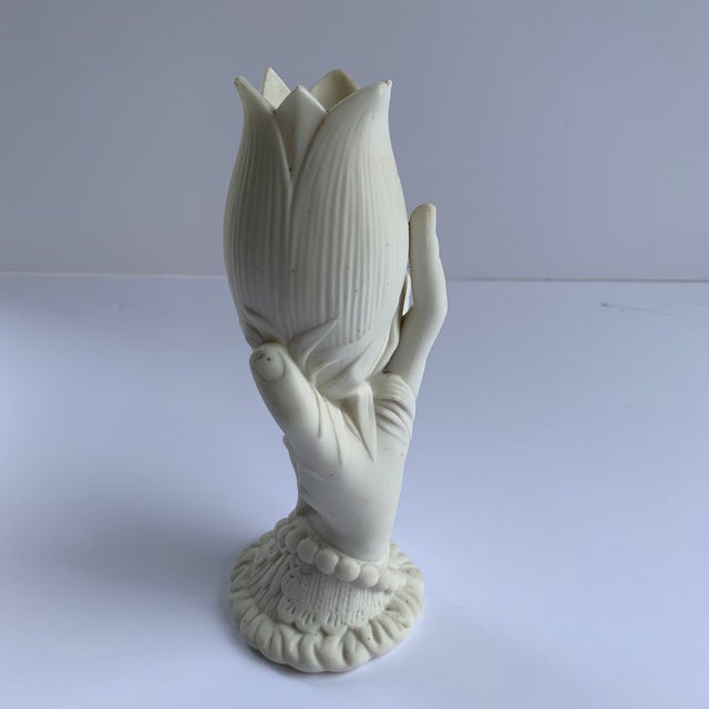 This finely detailed white hand sculpture is holding an enlarged lily blossom that is striking and one of a kind with no...