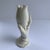 This finely detailed white hand sculpture is holding an enlarged lily blossom that is striking and one of a kind with no...