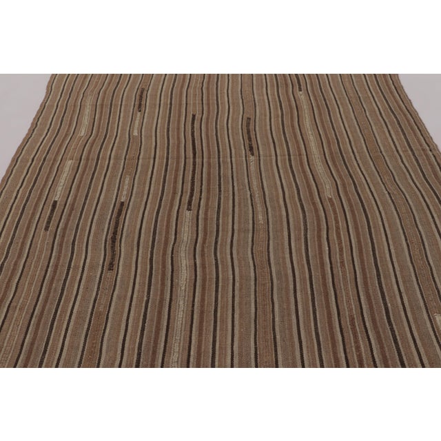 Made with handwoven wool circa 1950-1960, this 6x8 vintage Kilim is a particularly grounding and sought-after work of an...