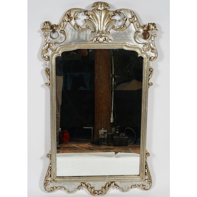 This is a vintage Italian Rococo style mirror . The frame is carved wood with a silvered or silver-gilt finish, featuring...