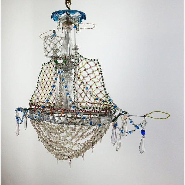 A beaded boat chandelier consisting of a tubular frame supporting sails made of beaded netting and various types of beads...