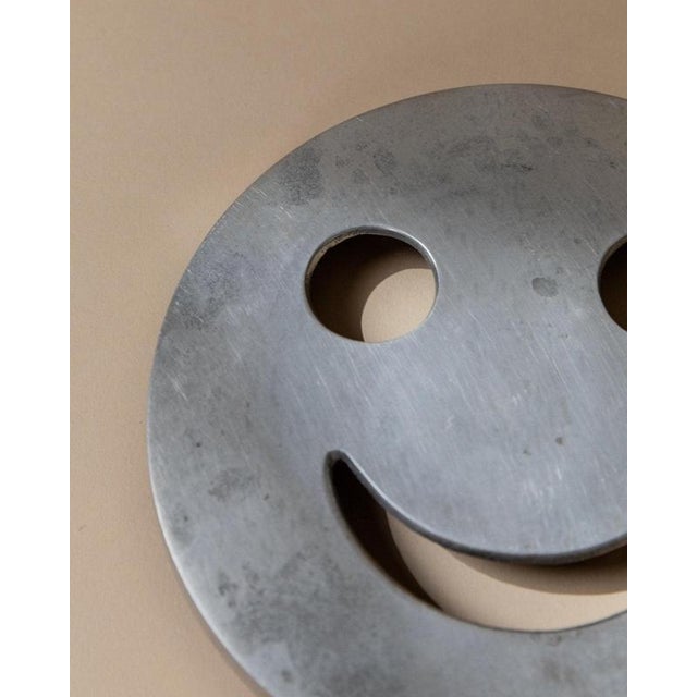 This playful vintage metal coaster from 1980s Italy brings a joyful touch to everyday life with its distinctive smiley-...