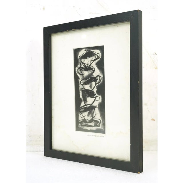 Black and white charcoal drawing featuring a stack of cups rendered in a tilted expressive style. The artist is Michael...