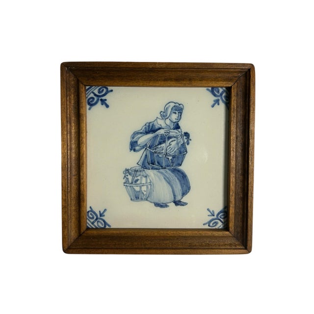 Set of four vintage hand-painted Tichelaar Makkum tiles, each set in a wooden frame. The tiles show traditional Dutch...