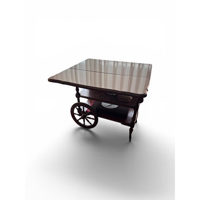 Mid-century mahogany tea cart or can be used as bar cart featuring hinged extension flaps on both sides, a lower storage...