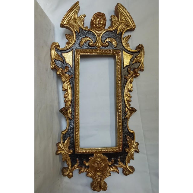 A vintage Italian Hollywood Regency Mirror or Picture Frame. The frame is carved wood with a gilt gold finish.