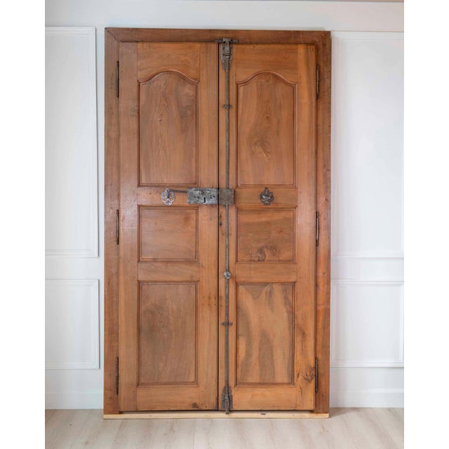 A nineteenth-century French communication door of double-leaf, double-sided construction in blond walnut, offered complete...
