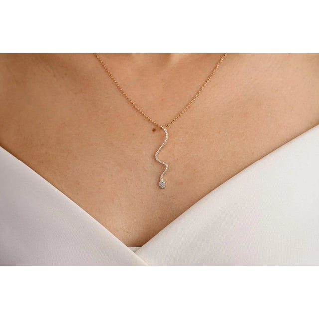 Minimalist Certified Diamond Serpent Snake Pendant Necklace in 18K Gold studded with round cut diamond. This stunning...