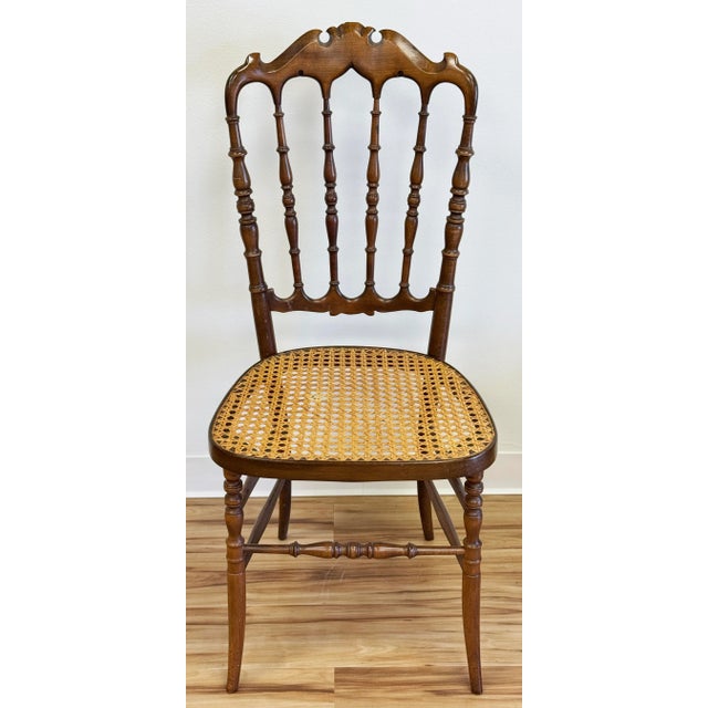 Vintage wood Chiavari style chair featuring carved spindle back and legs with caned seat. This would make a stunning...