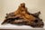 A striking circa-1970s carved mahogany sculpture depicting two reclining women. The figures emerge gracefully from an...