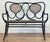 Unique vintage two seater bentwood settee bench featuring curved back, black stained frame and caned seat and back. Seat...