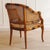 A faux-bamboo armchair, crafted as a high-quality replica based on Anglo-colonial models, circa 1970–1980. The curved...