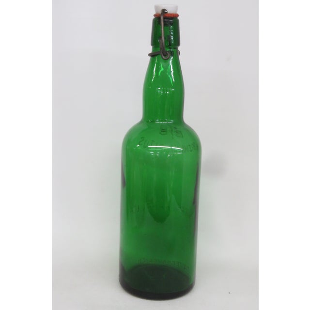 This gorgeous vintage bottle is made of stunning green glass and appears to have been used for flammable spirits. This...