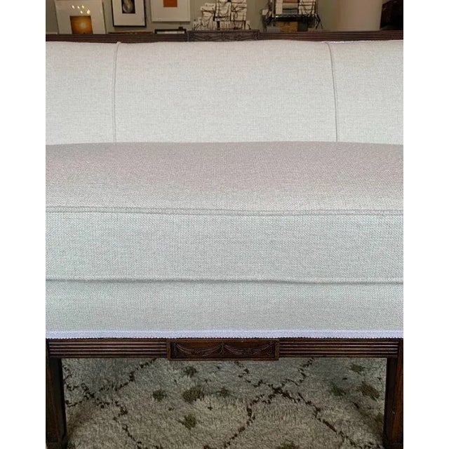 Late 19th Century French Sofa. This newly upholstered carved wood sofa has columnal legs and carved ornamental details to...