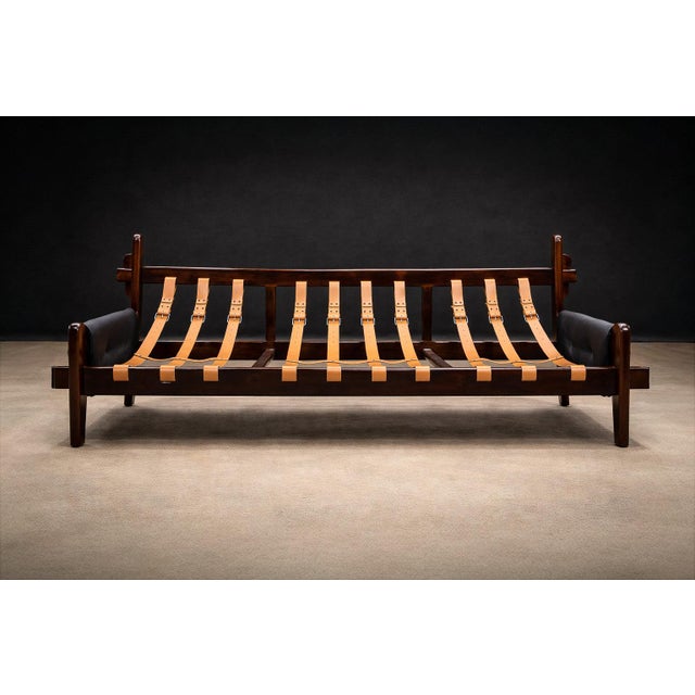 A sculptural three-seat sofa designed by Jean Gillon in the 1970s, executed in solid Brazilian rosewood (jacarandá) and...