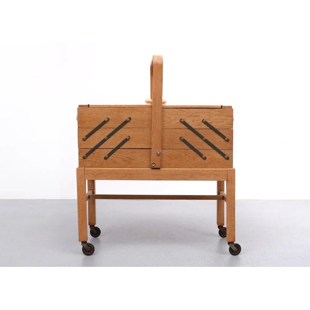 Large Solid Oak wood sewing box on wheels, opened with two hinged doors on the top, while the accordion style (with...