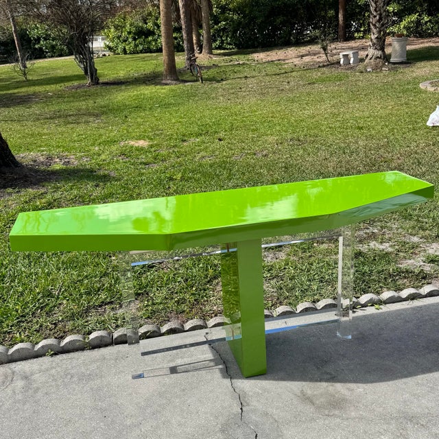 A vibrant Postmodern console table showcasing a striking high-gloss lime green laminate finish. The elongated geometric...