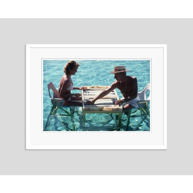 Keep Your Cool' by Slim Aarons Open Edition Carmen Alvarez enjoying a game of backgammon with Frank ‘Brandy’ Brandstetter...
