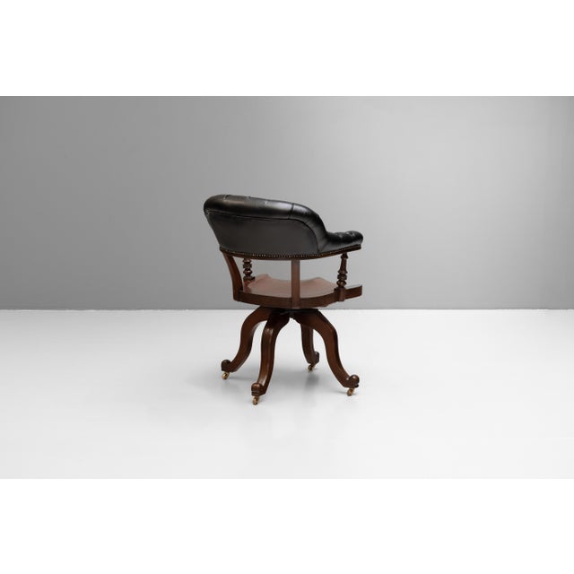 Mahogany office chair with shaped seat and deep buttoned back rail. Circa 1890.