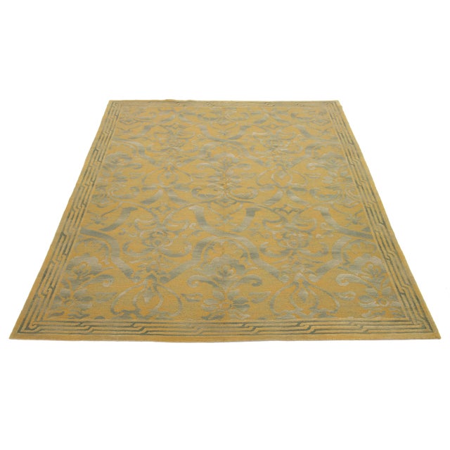 Needlepoint wool rug with a classical floral and vine motif in muted green and gold tones. Hand-stitched with fine detail,...