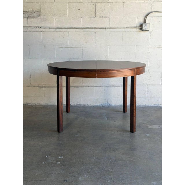 This extendable round dining table features a minimalist silhouette and sturdy tapered legs. In style of Bertil Fridhagen,...