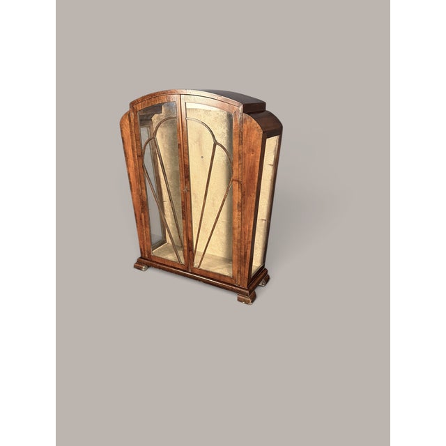An elegant Art Deco display cabinet from around 1930 with a characteristically curved, architecturally designed front. The...