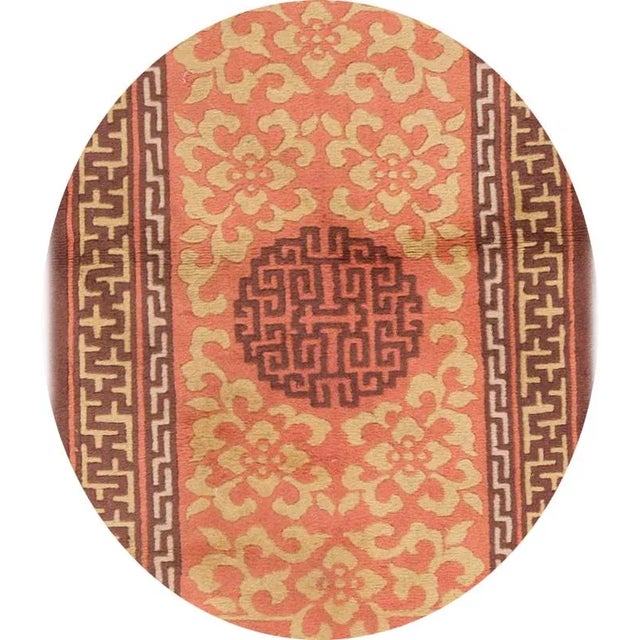 A vintage hand-knotted Chinese rug with an allover floral design on a light orange field. This rug has magnificent...