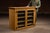 Mustard-painted wooden display cabinet with a rectangular case form, fitted with a pair of glazed front doors opening to a...