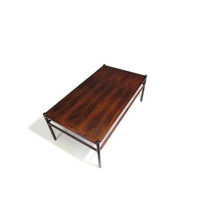 Finely crafted 1950's Scandinavian coffee table with a minimalist design, featuring elegantly carved cross stretchers and...