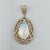 A striking vintage statement pendant centred by a large pear-shaped cabochon opal, displaying a beautiful shifting play of...
