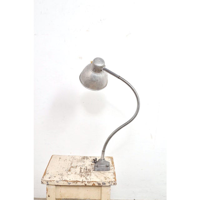 Flexible workshop lamp from the 1950s with on/off switch on the aluminum shade. The flexible arm can be adjusted at the...